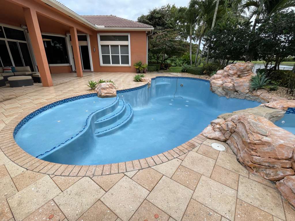 Drained South Florida pool during resurfacing, showing a freshly applied light-blue interior finish