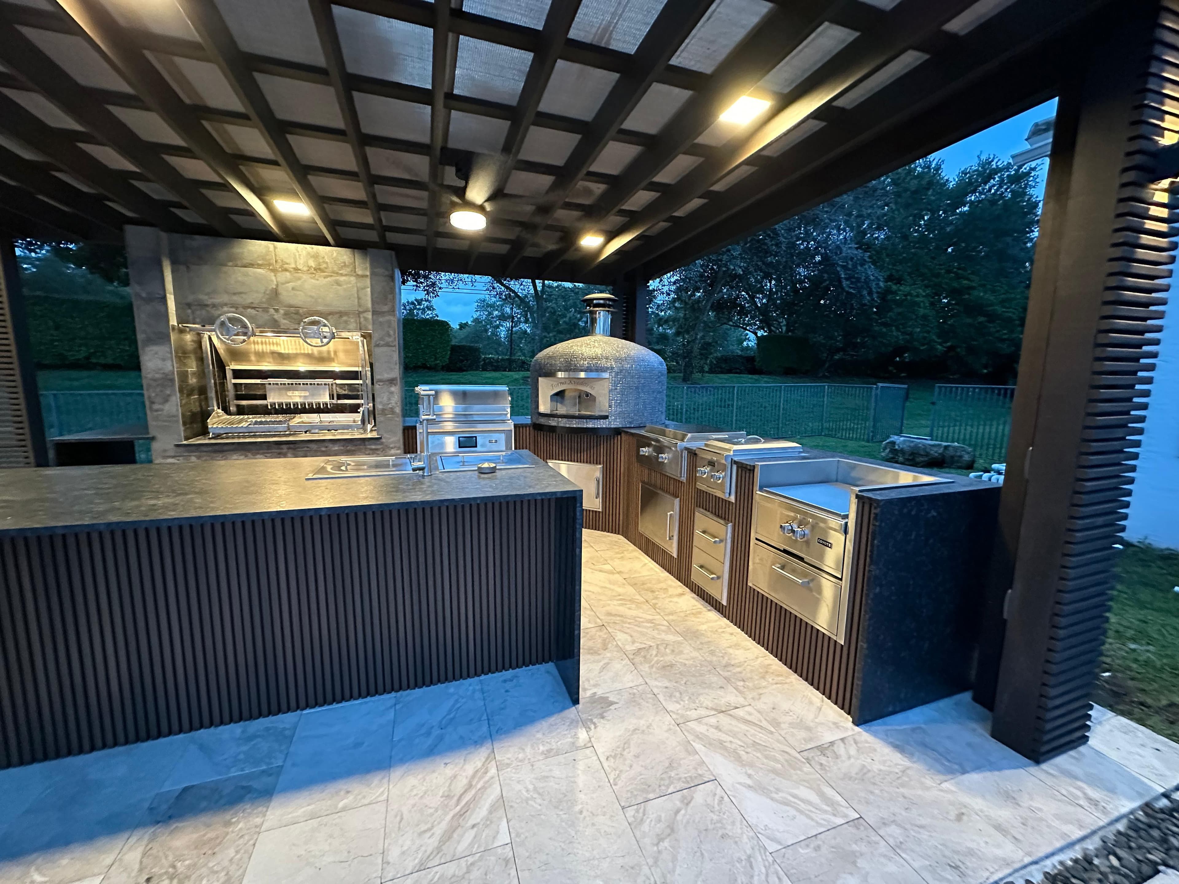 Luxury outdoor kitchen with pergola, pizza oven, and built-in grill for outdoor entertaining